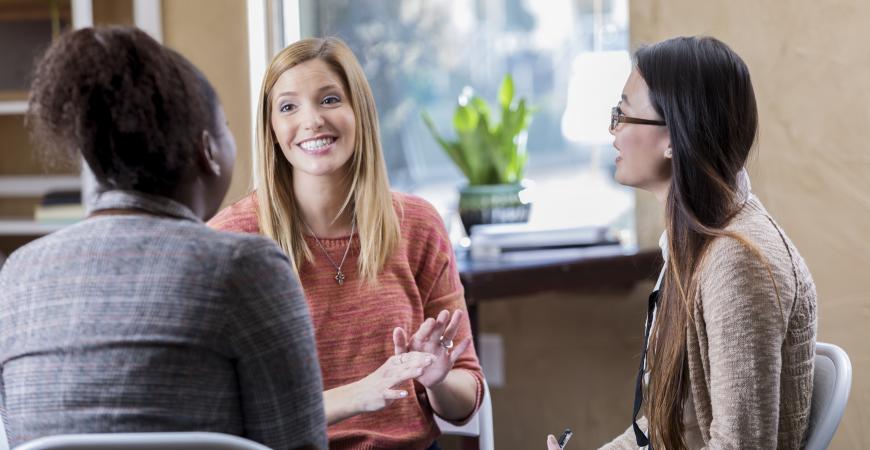 Three individuals talking in a private office