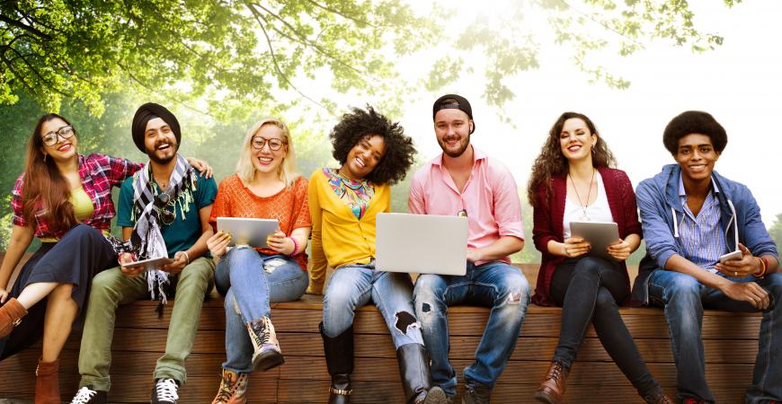 Groupe de jeunes adultes assis sur un banc à l'extérieur